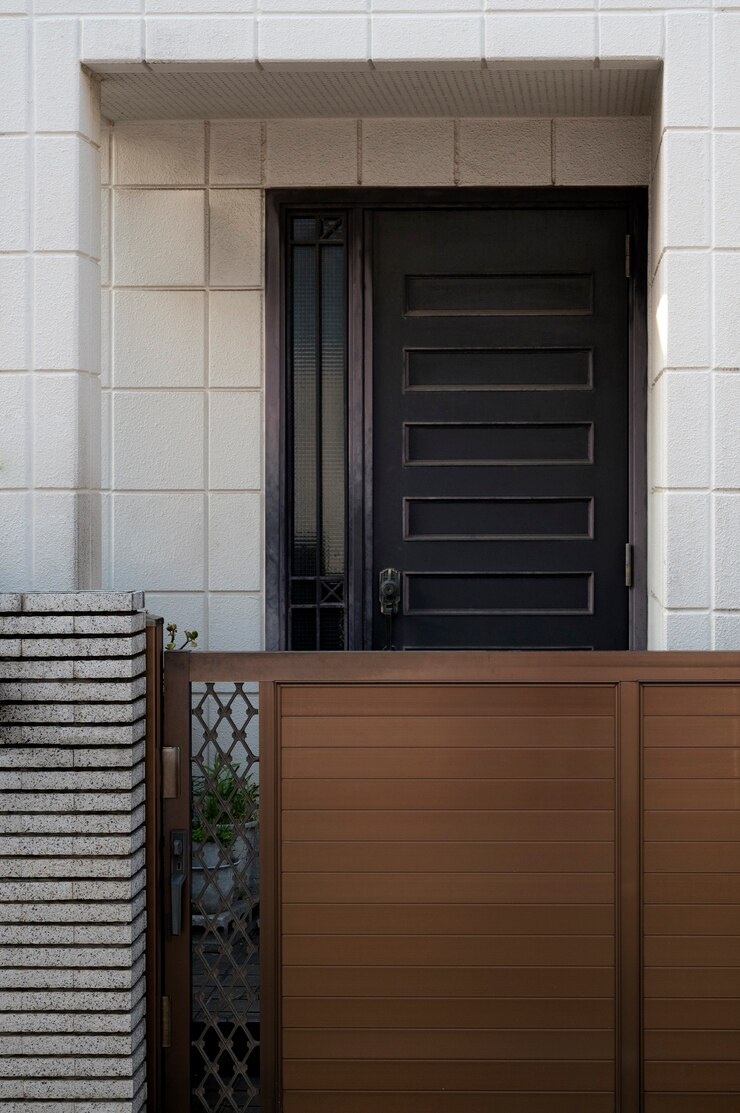 a modern fiberglass garage door. Fiberglass garage doors are known for their durability, lightweight properties, and resistance to rust and corrosion. They often feature contemporary designs and can mimic the appearance of wood, as seen here with the sleek paneling