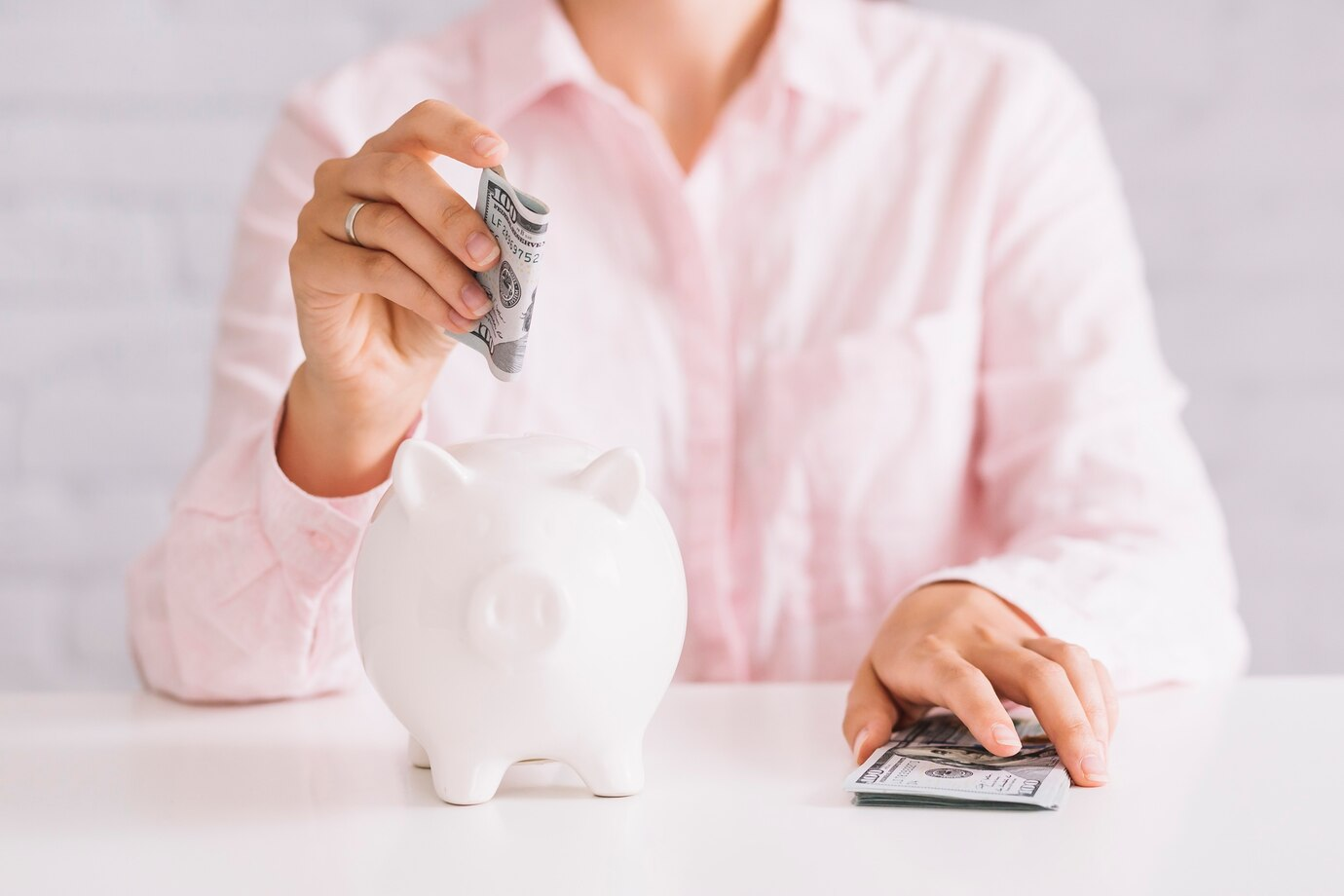 A woman throws money into a piggy bank