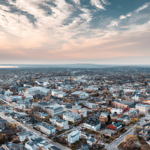 an aerial view of the Chelsea area, capturing the dense urban layout and buildings, likely a mix of residential, commercial, and industrial structures. The skyline extends towards the horizon, showing the area's integration with the surrounding landscape