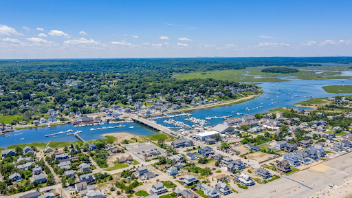 an aerial view of Marshfield, MA, showcasing a picturesque coastal town with a marina, residential areas, and waterways surrounded by greenery